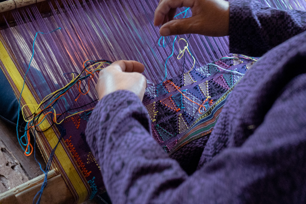 a woman weaving a fabric