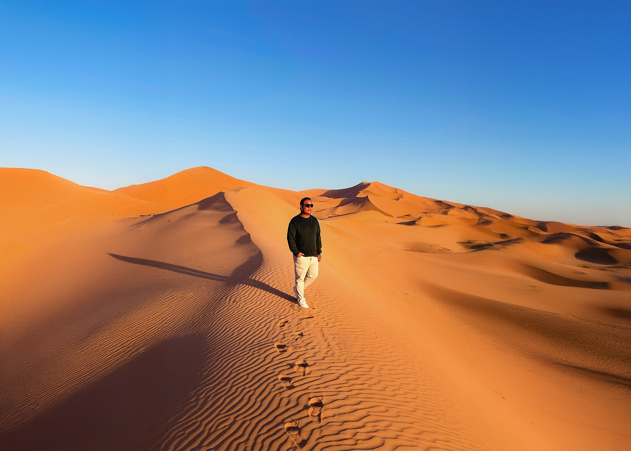 a man standing on the sand dunes
